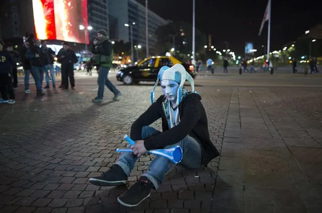 An Argentina soccer fan sits on the sidewalk after watching his team loose the final Copa America match to Chile, in downtown Buenos Aires, Argentina, Saturday, July 4, 2015. Argentina lost in a penalty shootout. (Photo by Ivan Fernandez/AP Photo)