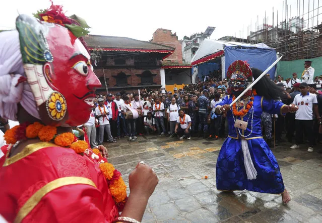 Masked dancers perform a traditional dance during Indra Jatra festival, an eight-day festival that honors Indra, the Hindu god of rain, in Kathmandu, Nepal, Friday, September 13, 2019. During this festival, families gather for feasts and at shrines to light incense for the dead, and men and boys in colorful masks and gowns representing Hindu deities dance to the beat of traditional music and devotees' drums, drawing tens of thousands of spectators to the city's old streets. (Photo by Niranjan Shrestha/AP Photo)