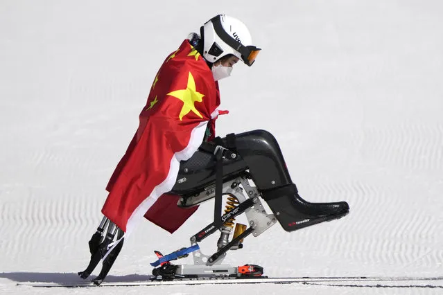 Zhang Wenjing of China leaves after the flower ceremony in the women's super G, sitting, at the 2022 Winter Paralympics, Sunday, March 6, 2022, in the Yanqing district of Beijing. (Photo by Andy Wong/AP Photo)