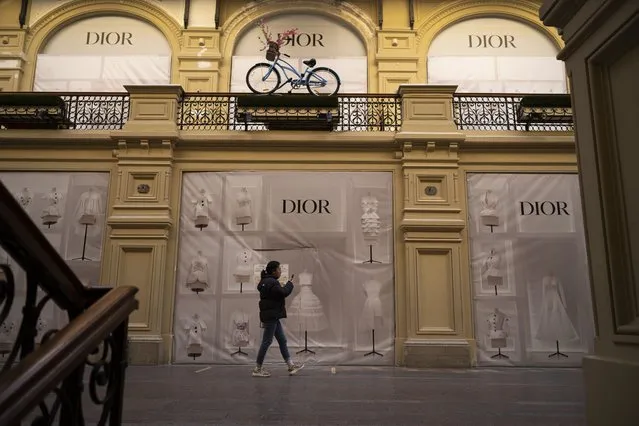 A visitor walks past a closed Dior boutique inside the GUM department store in Moscow, Russia, Wednesday, March 9, 2022. (Photo by AP Photo/Stringer)