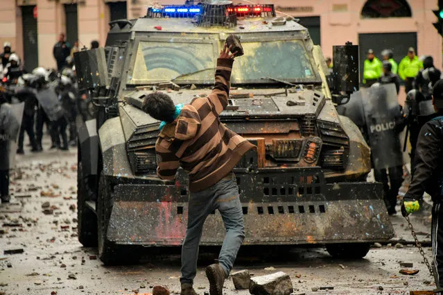 A demonstrator clashes with riot police during a transport strike against the economic policies of the government of Ecuadorean President Lenin Moreno regarding the agreement signed on March with the International Monetary Fund (IMF), in Quito, on October 3, 2019. The Ecuadorean government confirmed possible labour and tax reforms as established in the agreement, Economy Minister Richard Martinez stated -a day after announcing the elimination of fuel subsidies. (Photo by Rodrigo Buendía/AFP Photo)