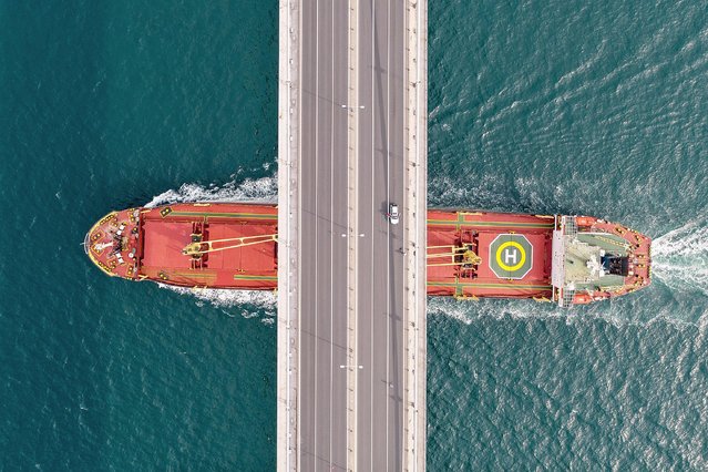 A ship makes its way up the Bosphorus strait as small number of cars cross a near empty July 15 Martyrs' Bridge (Bosphorus Bridge) during a two-day lockdown imposed to prevent the spread of COVID-19 on April 19, 2020 in Istanbul, Turkey. For the second weekend Turkey has lockdown more than two dozen cities, including Istanbul and the capital, Ankara. Turkey has reported over 86,000 cases of COVID-19 and over 2,000 related deaths. (Photo by Burak Kara/Getty Images)