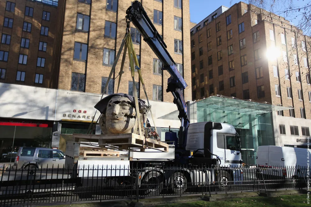 Giant Stone Heads Created By British Sculptor Emily Young Are Winched Into Berkeley Square