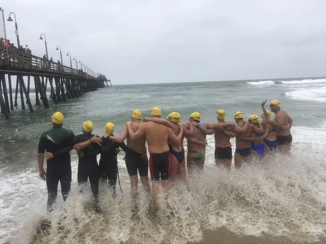 Athletes from six countries join arms before swimming off from Imperial Beach, Calif., to Mexico, in what they say is a show of solidarity with immigrants on Friday, May 5, 2017. The swimmers from the United States, Mexico, Israel, New Zealand and South Africa were escorted by a Mexican Navy ship as they reached a beach in Tijuana, a short distance from a border fence that juts into the Pacific Ocean. (Photo by Elliot Spagat/AP Photo)