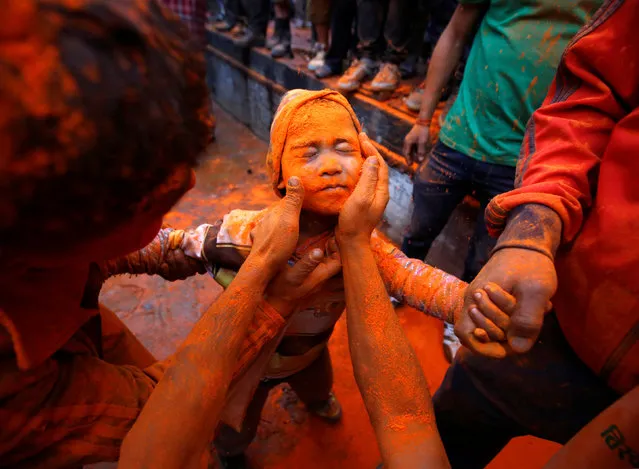 A boy gets his face smeared with vermillion powder during “Sindoor Jatra” vermillion powder festival at Thimi, in Bhaktapur, Nepal April 15, 2017. (Photo by Navesh Chitrakar/Reuters)
