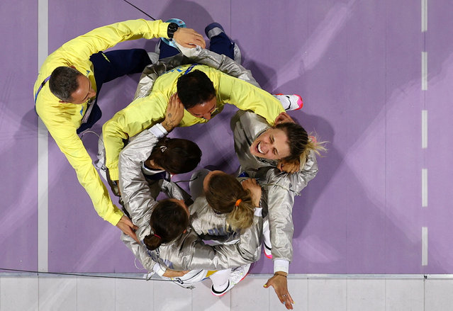 An overview shows Ukraine's Olga Kharlan (top R) celebrating with teammates after winning in the women's sabre team gold medal bout between South Korea and Ukraine during the Paris 2024 Olympic Games at the Grand Palais in Paris, on August 3, 2024. (Photo by Albert Gea/Reuters)