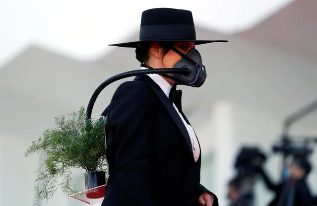 A guest wearing an oxygen mask arrives for the opening ceremony and the screening of the film “Madres Paralelas” (Parallel Mothers) on the opening day of the 78th Venice Film Festival, on September 1, 2021 at Venice Lido. (Photo by Yara Nardi/Reuters)