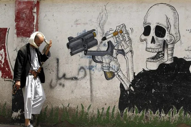 A Yemeni passes a wall sprayed with anti-smoking graffiti on World No Tobacco Day in Sana’a, Yemen, 31 May 2016. World No Tobacco Day is marked annually on 31 May to raise awareness of the health risks of tobacco use and to push advocacy for policies to reduce tobacco consumption. (Photo by Yahya Arhab/EPA)