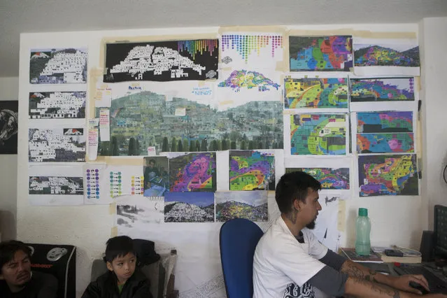 Blueprints and photos are displayed in the headquarters of the artist collective German Crew in Pachuca, Mexico, Thursday, July 30, 2015. German Crew has been working for a year and two months to create what they claim is Mexico's largest mural. The creative collective has used 20,000 liters of paint on 209 houses. (Photo by Sofia Jaramillo/AP Photo)