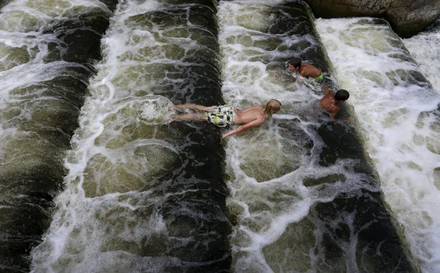 Young boys cool off in a weir on the Berounka river close to a village of Dobrichovice, Czech Republic, Thursday, August 6, 2015. The temperatures in the Czech Republic have reached record highs in the recent heat wave. (Photo by Petr David Josek/AP Photo)