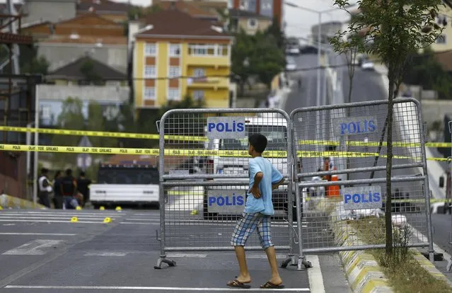 A boy watches in front of a police barrier after an attack on a police station in Istanbul, Turkey August 10, 2015. Four Turkish police officers were confirmed dead and one wounded by roadside explosives in an attack by Kurdish militants, the governor's office in the southeast Sirnak province said on Monday. (Photo by Huseyin Aldemir/Reuters)