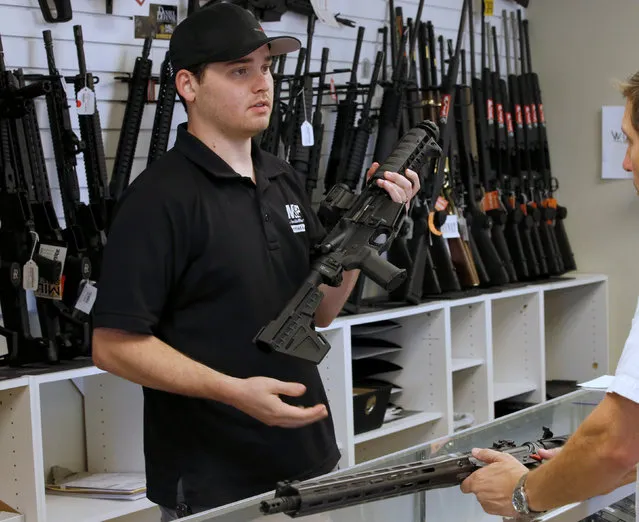 Salesman Ryan Martinez shows a prospective buyer an AR-15 at the “Ready Gunner” gun store in Provo, Utah, U.S., June 21, 2016. (Photo by George Frey/Reuters)