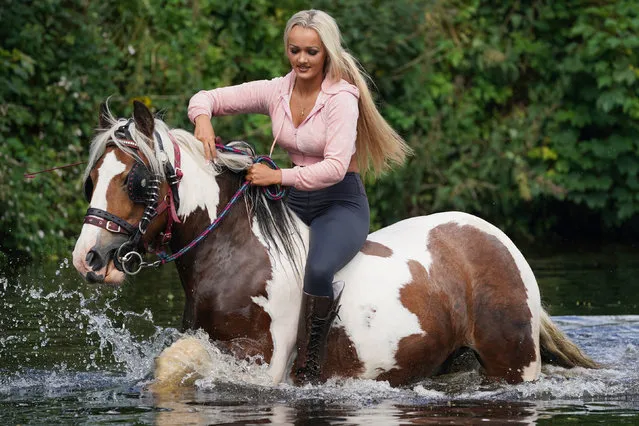 A woman rides her horse in the River Eden on Friday June 10, 2022, on Day 2 of the Appleby Horse Fair, the annual gathering of gypsies and travellers. (Photo by Owen Humphreys/PA Wire Press Association)