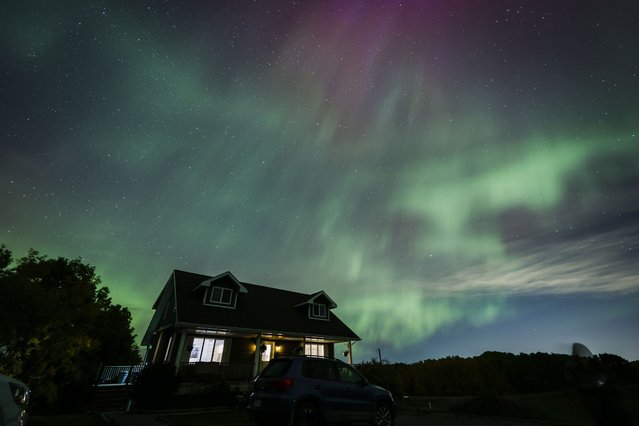 An aurora borealis, also known as the northern lights, is seen over a home near Cremona, Alberta, Monday, October 7, 2024. (Photo by Jeff McIntosh/The Canadian Press via AP Photo)