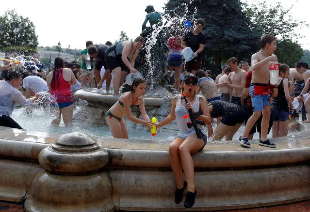 People take part in a water fight in the centre of Budapest, Hungary, June 25, 2016. (Photo by Laszlo Balogh/Reuters)