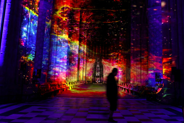 A person walks at the art installation Space by Luxmuralis inside Durham Cathedral in Durham, Britain on October 8, 2024. (Photo by Lee Smith/Reuters)