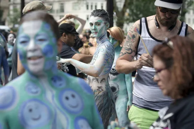 Marion La Coguic, of Portland, Ore., is painted at Columbus Circle as body-painting artists gathered to decorate nude models as part of an event featuring artist Andy Golub, Saturday, July 26, 2014, in New York. Golub says New York was the only city in the country that would allow his inaugural Bodypainting Day. (Photo by John Minchillo/AP Photo)