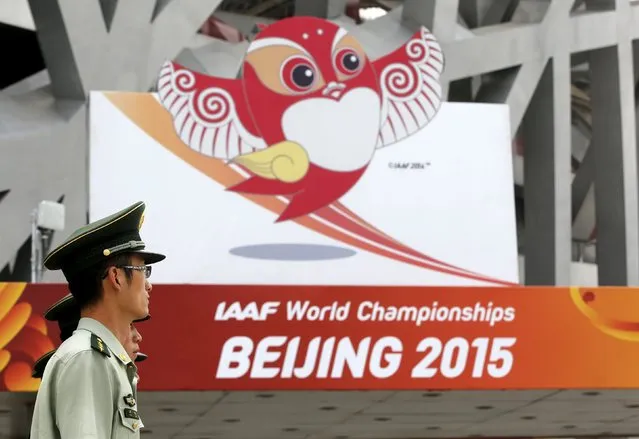 Paramilitary policemen listen to instructions in front of the logo of the upcomming 15th IAAF World Championships at the Beijing National Stadium, also known as the Bird's Nest, in Beijing, China, August 17, 2015. Beijing will host the 15th IAAF World Championships from August 22 to 30, 2015. (Photo by Fabrizio Bensch/Reuters)