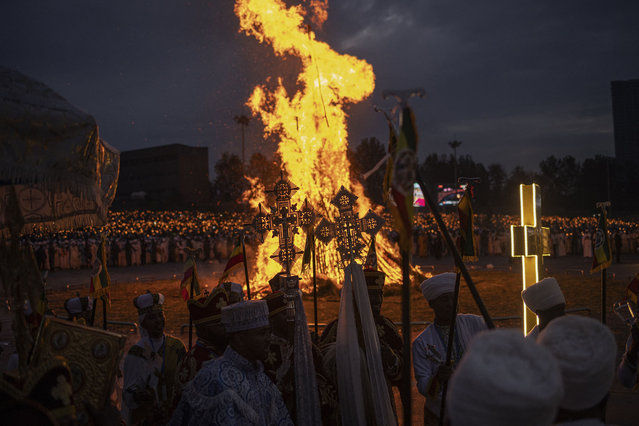 High priests hold crosses as they sing in front of a bonfire during celebrations of the Ethiopian Orthodox holiday of Meskel, in Addis Ababa, on September 26, 2024. The Ethiopian Meskel celebration is an annual religious holiday in the Ethiopian Orthodox church that commemorates the discovery of the True Cross in the fourth century by the Roman Empress Helena. (Photo by Michele Spatari/AFP Photo)