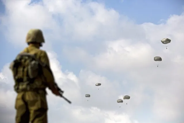 Israeli army paratroopers take part in a training jump in full battle gear over the Palmachim military base near Tel Aviv, Israel, 05 July 2016. Although the Paratroopers Brigade has had only one operational combat parachute drop ever, during the 1956 Sinai War, volunteers accepted into the elite unit undergo operational training jumps with all the equipment needed for battle. (Photo by Abir Sultan/EPA)