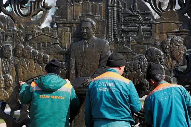Municipal workers clean the bas-relief of Kazakh former President Nursultan Nazarbayev in Almaty, Kazakhstan March 1, 2020. (Photo by Pavel Mikheyev/Reuters)