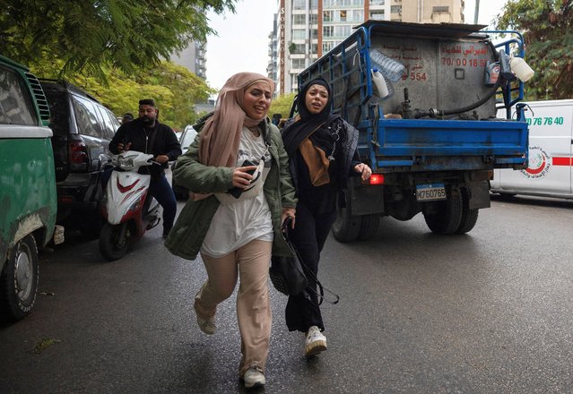 Girls react as they run for cover after an Israeli strike on a building, that according to security sources killed Hezbollah's media relations chief Mohammad Afif, in Ras Al- Nabaa, Beirut, Lebanon on November 17, 2024. (Photo by Adnan Abidi/Reuters)