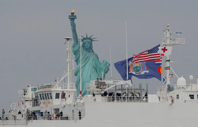 The USNS Comfort passes the Statue of Liberty as it enters New York Harbor during the outbreak of the coronavirus disease (COVID-19) in New York City, U.S., March 30, 2020. (Photo by Brendan McDermid/Reuters)