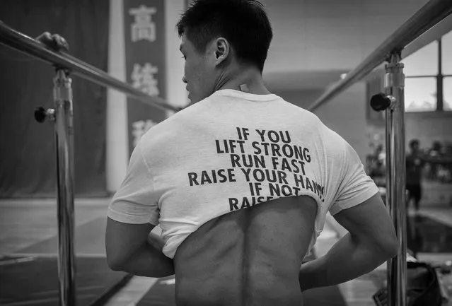 Chinese weightlifter Lu Xiaojun, who competes in the 77 kg weightclass, puts on a shirt during a training session in preparation for the Rio Olympics at the Training Center of General Administration of Sports in China on July 15, 2016 in Beijing, China. Xiaojun has won 5 World Championships, a gold medal at the 2012 Olympics and is a world record holder. (Photo by Kevin Frayer/Getty Images)