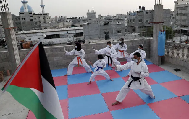 The karate coach of Khaled Sheikh el Eid, front, and his sons and daughters, train together on the roof of their family house, during the coronavirus pandemic, at Rafah refugee camp, southern Gaza Strip, Wednesday, April 22, 2020. (Photo by Adel Hana/AP Photo)