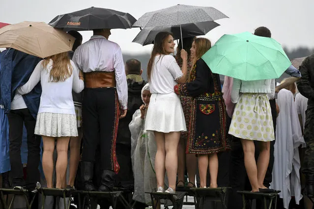 People sit atop chairs as they watch Pope Francis' departure at Balice airport near Krakow, Poland July 31, 2016. (Photo by Michal Lepecki/Reuters/Agencja Gazeta)