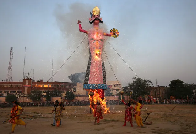 Artists dressed as Hindu gods react as an effigy of Kumbhkarana, brother of demon king Ravana, burns during Vijaya Dashmi or Dussehra festival celebrations in Jammu September 30, 2017. (Photo by Mukesh Gupta/Reuters)