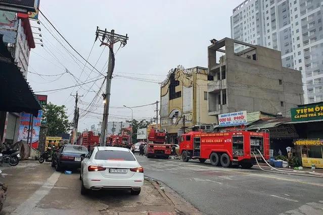 Fire department trucks line outside a karaoke parlor following a fire Wednesday, September 7, 2022, in Thuan An city, southern Vietnam. Over a dozen people died in the fire local media reported. (Photo by Duong Trei Tuong/VNA via AP Photo)