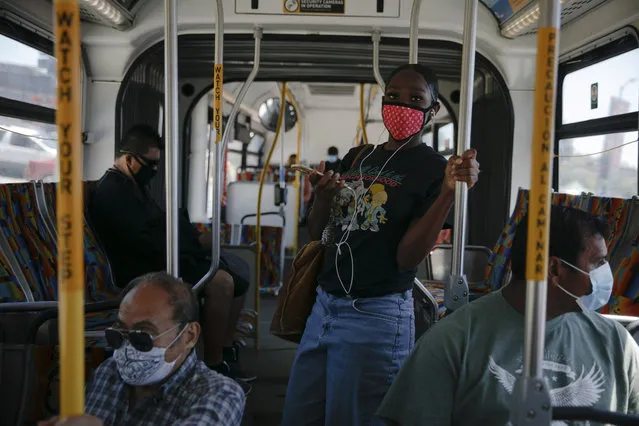 Commuters wearing masks ride a bus during the coronavirus pandemic in the Vermont Square neighborhood of Los Angeles, Thursday, May 21, 2020. While most of California took another step forward to partly reopen in time for Memorial Day weekend, Los Angeles County didn't join the party because the number of coronavirus cases has grown at a pace that leaves it unable to meet even the new, relaxed state standards for allowing additional businesses and recreational activities. (Photo by Jae C. Hong/AP Photo)