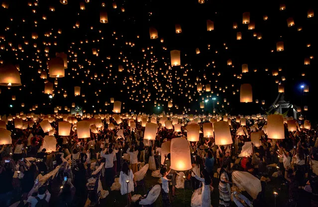 A crowd releases lanterns into the air as they celebrate the Yee Peng festival, also known as the festival of lights, in Chiang Mai, Thailand on November 3, 2017. This event is part of the festival of lights in Northern Thailand to show respect to Buddha. (Photo by Reuben Easey/AFP Photo)