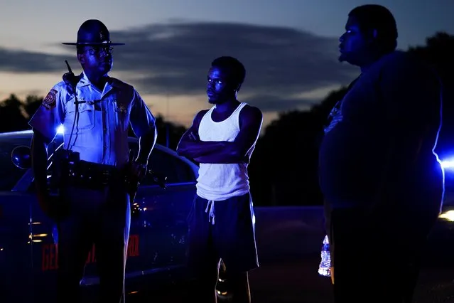 Two protesters speak with a Georgia State Patrol officer after taking over and blocking a freeway during a rally against racial inequality and the police shooting death of Rayshard Brooks, in Atlanta, Georgia, June 13, 2020. (Photo by Elijah Nouvelage/Reuters)