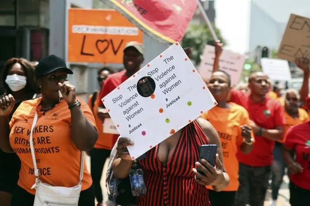 Women's rights group members protest outside the Johannesburg Magistrates court in downtown Johannesburg, Tuesday, October 11, 2022. A 21-year-old male has appeared in the court in connection with the discovery of six bodies at a car repair workshop in the city. (Photo by AP Photo/Stringer)