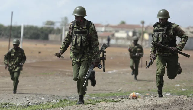 Police run during clashes with opposition supporters in the Jacaranda grounds quarter in Nairobi, Kenya, Tuesday, November 28, 2017. (Photo by Brian Inganga/AP)