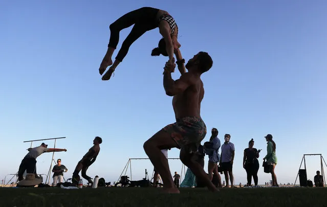 A duo practice acro along Santa Monica beach amid the COVID-19 pandemic on July 2, 2020 in Santa Monica, California. Beginning July 3, Los Angeles County beaches and piers will be closed through the July 4th holiday weekend amid some reinstated restrictions intended to slow the spread of the coronavirus. (Photo by Mario Tama/Getty Images)