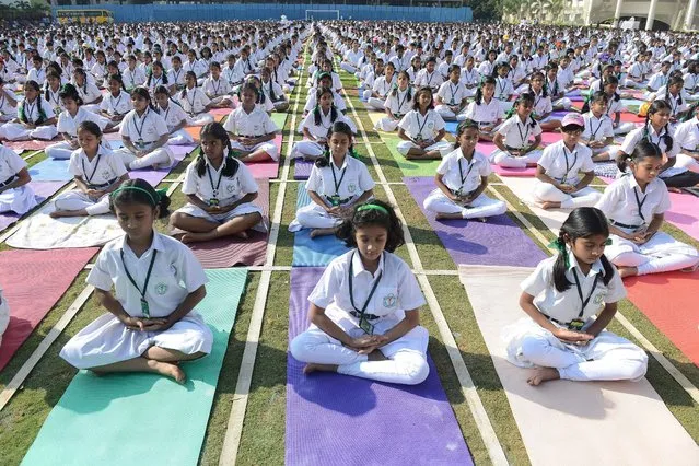 Indian students of Delhi Public School perform yoga in Hyderabad on October 20, 2014. Nearly 5000 students including teachers perform seven yogic postures, with religious prayers for world harmony and peace. (Photo by Noah Seelam/AFP Photo)