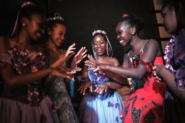 Mitchelle Mulari, 15, (C) and Watiri Nduba, 18, (2nd R) react with other dancers at the side of the stage during The Nutcracker, a ballet primarily performed in the Christmas period, by the Dance Centre Kenya (DCK) with the Nairobi Philharmonic Orchestra at the National Theatre in Nairobi on December 4, 2022. (Photo by Yasuyoshi Chiba/AFP Photo)