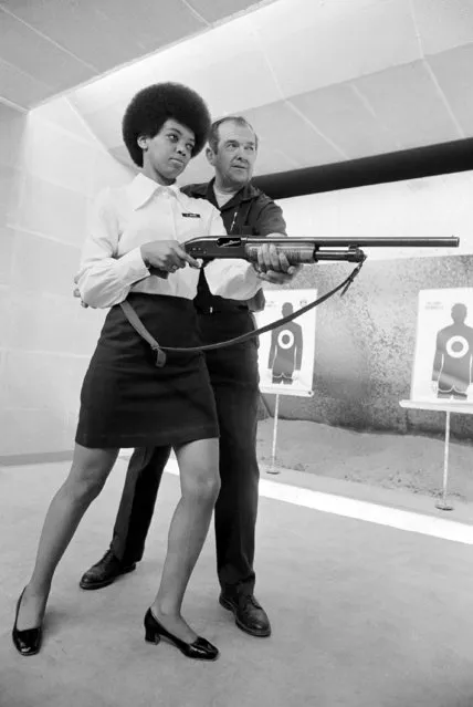 Saundra Brown, 28, the first black woman on the Oakland police force gets instructions on how to shoot a shotgun from the hip by police range master Adolph Bischofberger on December 16, 1970 in Oakland, California. Saundra graduates on Friday near the top of her class after 15 weeks of criminal law, report writing, first aid, firearms training and defensive tactics. “I really feel very confident now”, she said, “but before I was totally afraid. I didn't want to be around a gun”. (Photo by Robert Klein/AP Photo)