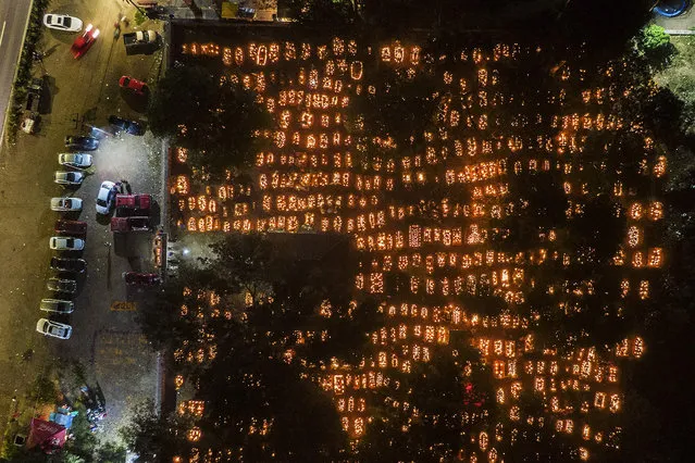 Aerial view of a cemetery during the Night of the Dead celebrations in the framework of the Day of the Dead in the Purepecha indigenous community of Cucuchucho, on the shores of Lake Patzcuaro, Michoacan state, Mexico, on November 2, 2022. People adorn the tombs of the dead and remain in the pantheon throughout the night waiting for their relatives. Tradition says that on the night of November 1 and early morning of November 2, the souls of the dead return to the world of the living. (Photo by Enrique Castro/AFP Photo)