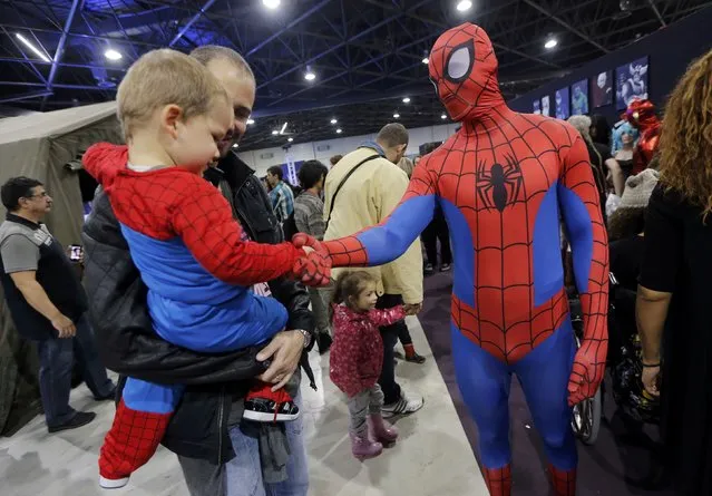 A participant dressed as superhero Spiderman greets a young fan during the first edition of the HeroFestival in Marseille, November 9, 2014. (Photo by Jean-Paul Pelissier/Reuters)