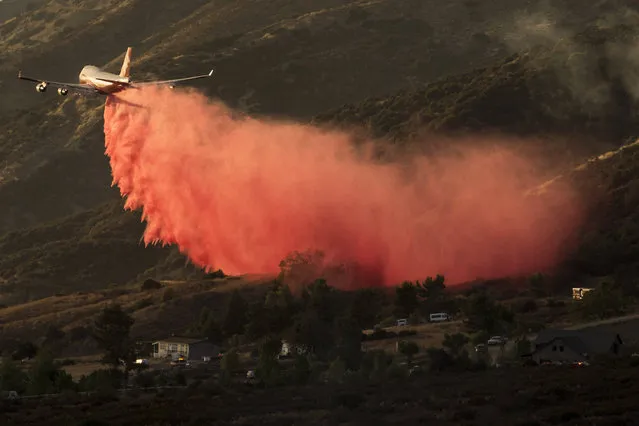 An air tanker drops retardant at a wildfire burns at a hillside in Yucaipa, Calif., Saturday, September 5, 2020. (Photo by Ringo H.W. Chiu/AP Photo)