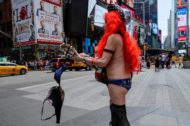 A street performer hangs her bra on her guitar during a hot and sunny day at Times Square in New York, U.S., July 17, 2016. (Photo by Eduardo Munoz/Reuters)