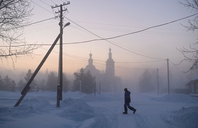 A pedestrian crosses a road while walking past a church on a frosty day in the Siberian town of Tara in the Omsk region, Russia on January 11, 2023. (Photo by Alexey Malgavko/Reuters)