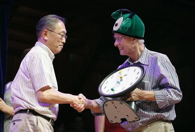 Atsuki Higashiyama, left, from Ritsumeikan University in Japan, accepts the Ig Nobel Perception Prize from Nobel laureate Rich Roberts (physiology or medicine, 1993) during ceremonies at Harvard University in Cambridge, Mass., Thursday, September 22, 2016. Higashiyama was awarded the prize for investigating whether things look different when you bend over and view them between your legs. (Photo by Michael Dwyer/AP Photo)
