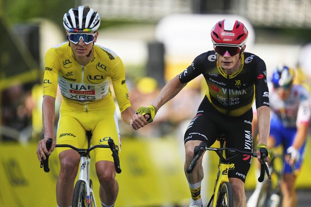 Slovenia's Tadej Pogacar, wearing the overall leader's yellow jersey, and Denmark's Jonas Vingegaard, cross the finish line hand-in-hand of the the tenth stage of the Tour de France cycling race over 165.3 kilometers (102.7 miles) with start in Ennezat and finish in Le Mont-Dore Puy de Sancy, France, Monday, July 14, 2025. (Photo by Mosa'ab Elshamy/AP Photo)