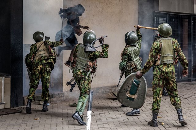 A protester jumps for safety as she emerges from a narrow alley while Kenyan police officers strike her with whips and clubs during a planned protest marking the first anniversary of the storming of the parliament in Nairobi, Kenya on June 17, 2025. At least 16 people were killed and 400 injured as a nationwide demonstration to honour those killed during last year’s anti-government protests turned chaotic, with police clashing with protesters in different parts of the country. (Photo by Luis Tato/AFP Photo)