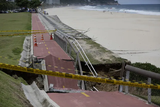 A bike path is seen partially collapsed after heavy rains in Rio de Janeiro, Brazil, Thursday, February 15, 2018. Heavy rain and high winds have left four people dead. Overnight storms flooded roads, downed trees and caused the partial collapse of the bike path. Several homes were damaged in the Alemao slum complex. (Photo by Silvia Izquierdo/AP Photo)